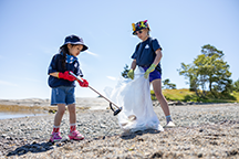 Two girls cleaning a beach