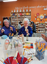 Maple Leaf Trefoil Guild members painting pottery