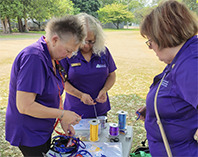 Three Trefoil Guild members making friendship knots.